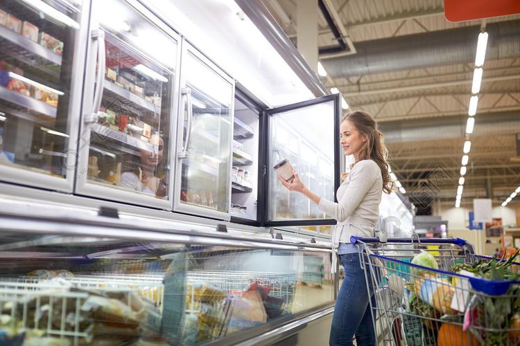 销售食品消费主义和人们观念购物车在杂货店冷冻店选择冰淇淋的女人